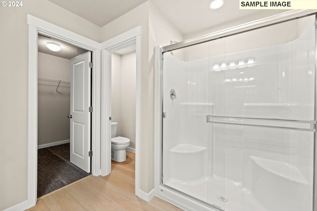 3118 S Magnolia Dr Unit Lt752, Cornelius, OR 97113 - bathroom with wood finished floors, a stall shower, toilet, baseboards, and a walk in closet