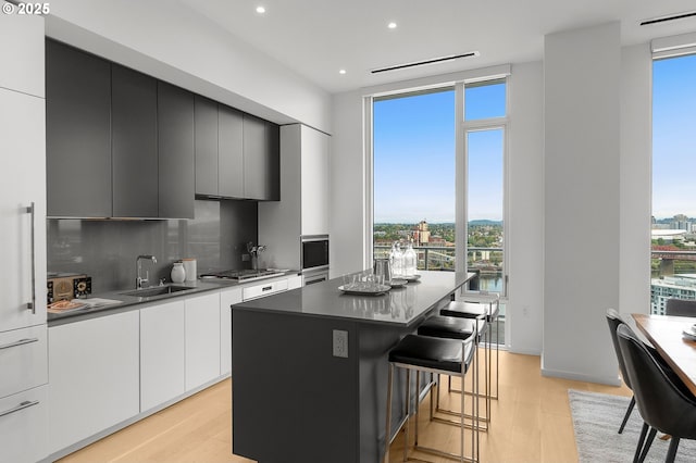 kitchen with a kitchen bar, a center island, plenty of natural light, and sink