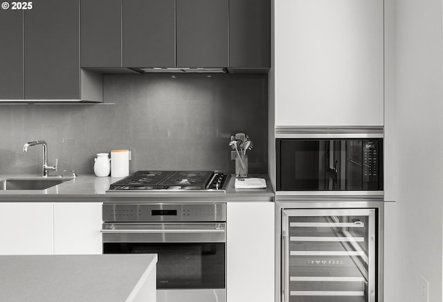 kitchen featuring decorative backsplash, sink, stainless steel appliances, and wine cooler