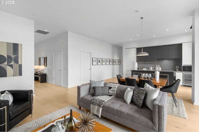 living room featuring wine cooler and light hardwood / wood-style floors