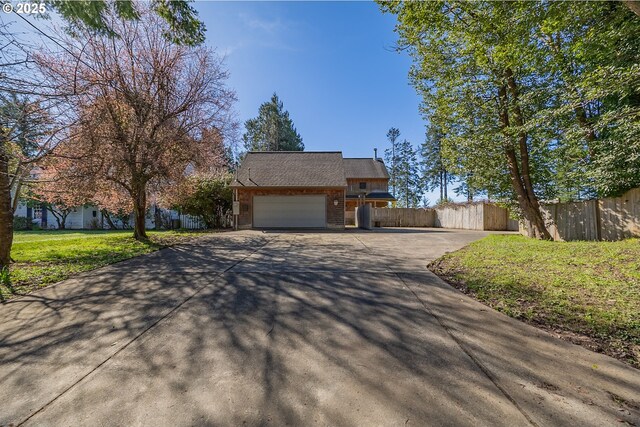 view of front facade with a garage, a front lawn, fence, and driveway