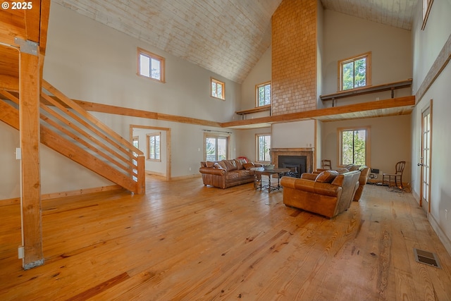living room with french doors, visible vents, a fireplace, hardwood / wood-style flooring, and high vaulted ceiling