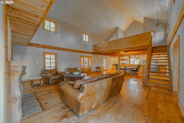 living room featuring stairway, high vaulted ceiling, plenty of natural light, and wood-type flooring