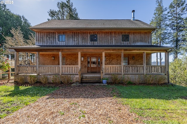 farmhouse inspired home with covered porch and a front yard