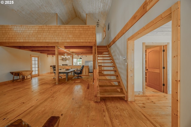 stairway with visible vents, high vaulted ceiling, a notable chandelier, and hardwood / wood-style flooring