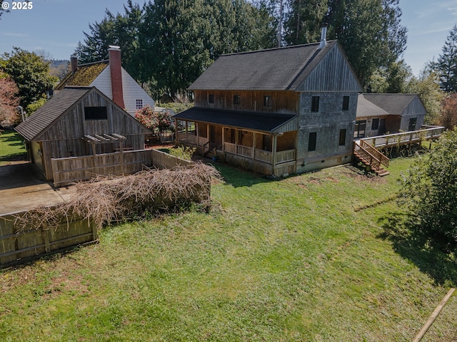 rear view of property with a lawn, a porch, stairway, and crawl space