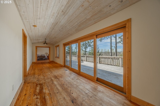 doorway with baseboards, lofted ceiling, wood ceiling, and hardwood / wood-style flooring
