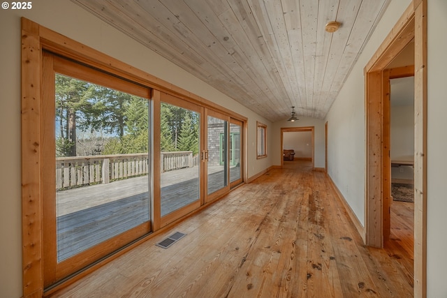 interior space featuring wood ceiling, plenty of natural light, light wood finished floors, and visible vents