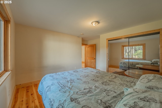 bedroom featuring baseboards and light wood finished floors
