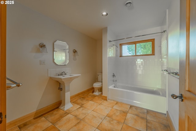 bathroom featuring washtub / shower combination, tile patterned flooring, baseboards, and toilet