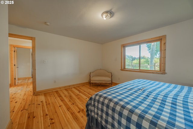 bedroom with baseboards and light wood finished floors