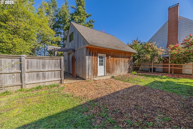 view of outdoor structure with a fenced backyard and an outbuilding