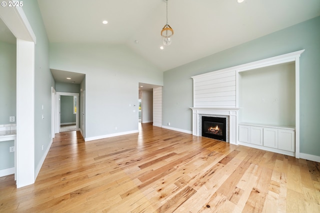 80654 Polo Ridge Rd, Warrenton, OR 97146 - unfurnished living room with light wood-style floors, a glass covered fireplace, lofted ceiling, and recessed lighting