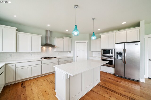 80654 Polo Ridge Rd, Warrenton, OR 97146 - kitchen featuring appliances with stainless steel finishes, wall chimney exhaust hood, backsplash, white cabinetry, and recessed lighting