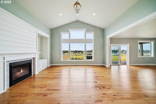 80654 Polo Ridge Rd, Warrenton, OR 97146 - unfurnished living room with lofted ceiling, light wood-style floors, and a tiled fireplace