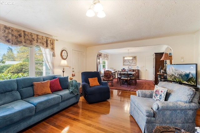 18050 SE Langensand Rd, Sandy, OR 97055 - living area featuring arched walkways, a chandelier, light wood-type flooring, and a textured ceiling