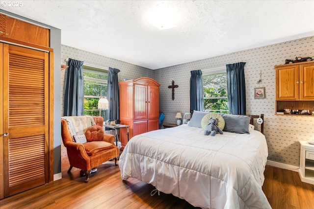 18050 SE Langensand Rd, Sandy, OR 97055 - bedroom with wallpapered walls, multiple windows, wood finished floors, baseboards, and a closet