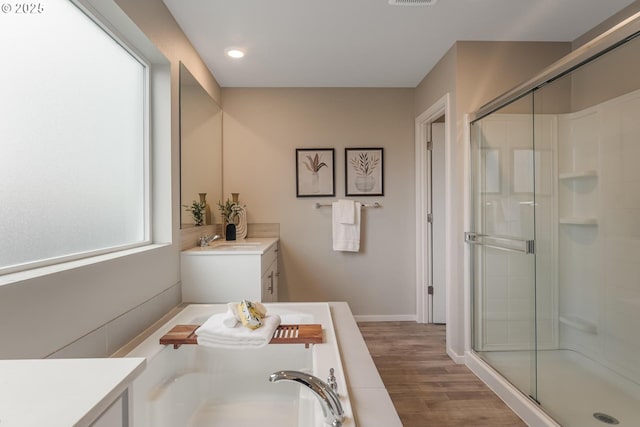 bathroom featuring hardwood / wood-style floors, vanity, and shower with separate bathtub