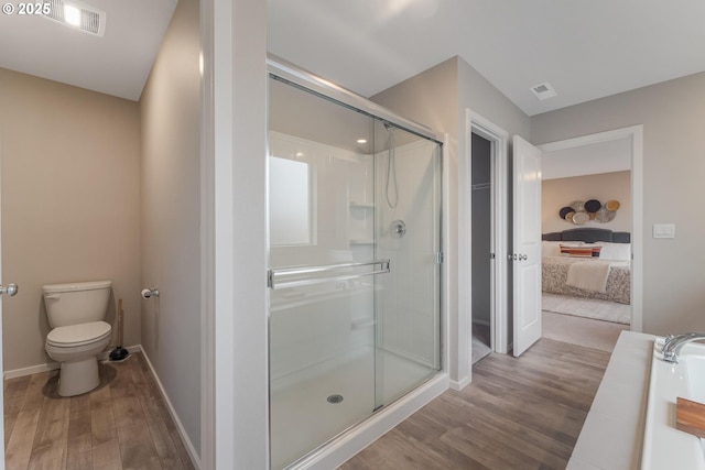 bathroom featuring wood-type flooring, shower with separate bathtub, and toilet