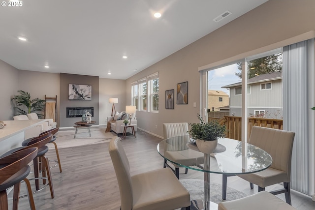 dining area with a fireplace and light hardwood / wood-style floors