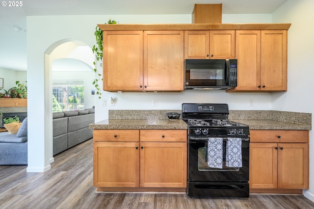 616 E 13th Pl, Lafayette, OR 97127 - kitchen with black appliances, wood finished floors, arched walkways, and stone countertops