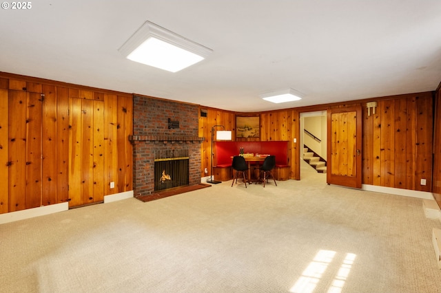 6040 SE 32nd Ave, Portland, OR 97202 - carpeted living room featuring wooden walls, a fireplace, and stairway