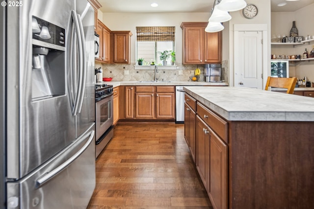 19459 Leland Rd, Oregon City, OR 97045 - kitchen featuring appliances with stainless steel finishes, a sink, light countertops, dark wood-type flooring, and brown cabinets