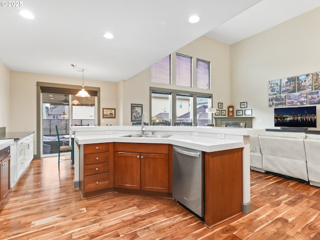 kitchen with dishwasher, a sink, open floor plan, brown cabinets, and light wood finished floors