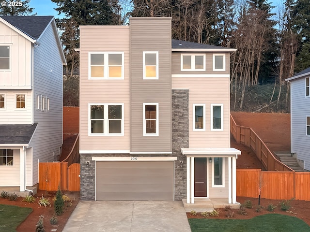 view of front of property with stone siding, driveway, and fence