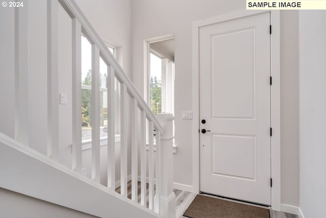 entryway with stairway and baseboards