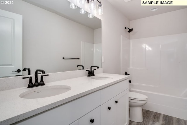 full bathroom featuring vanity, wood-type flooring, toilet, and washtub / shower combination