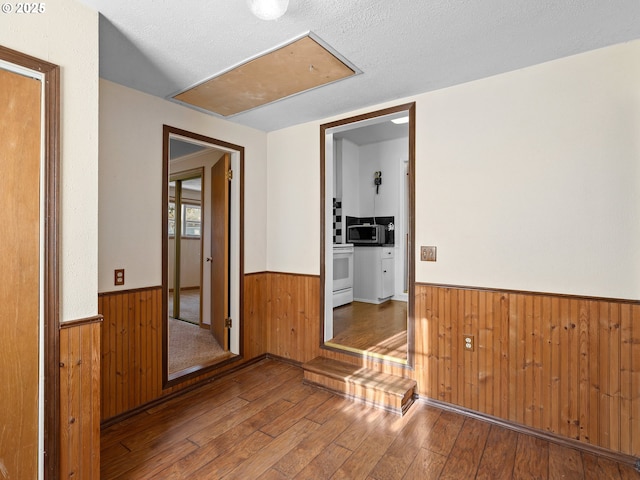 corridor featuring a textured ceiling and hardwood / wood-style flooring