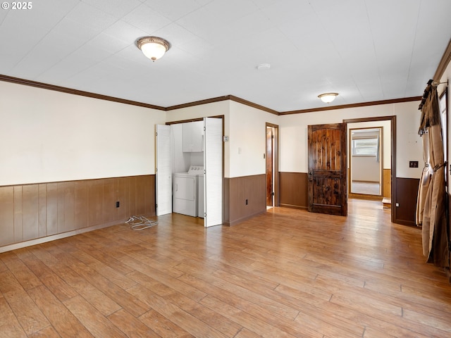 interior space with independent washer and dryer, ornamental molding, and light hardwood / wood-style flooring