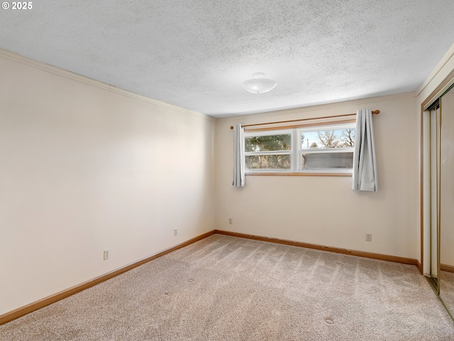 unfurnished bedroom featuring a textured ceiling, ornamental molding, and carpet flooring