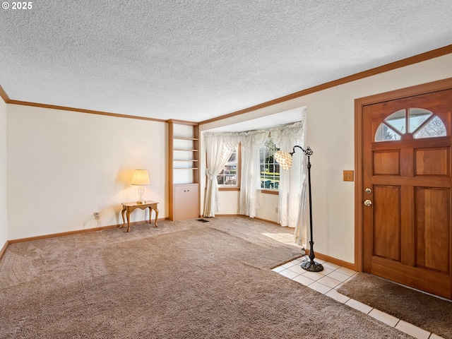 carpeted foyer entrance with a textured ceiling and ornamental molding