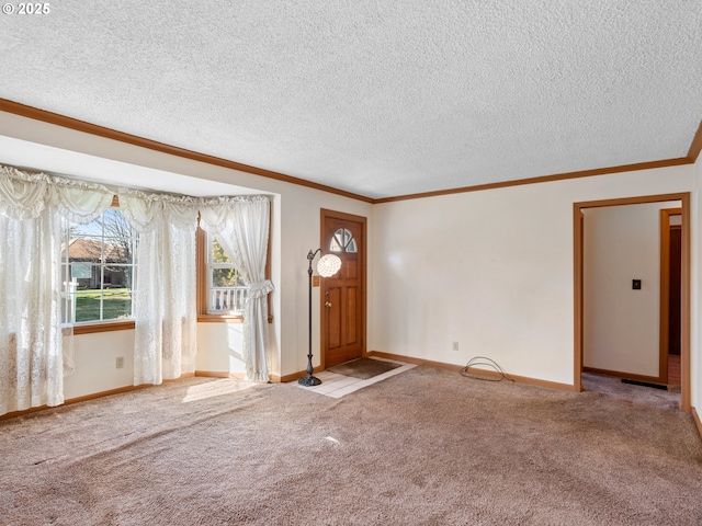 carpeted foyer entrance featuring a textured ceiling and ornamental molding