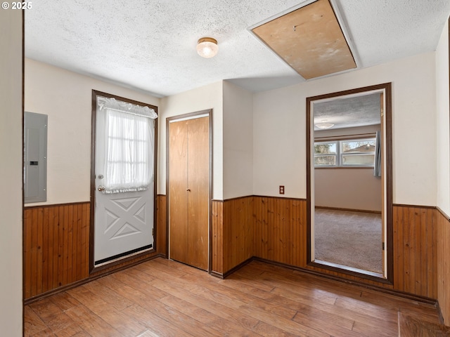 entryway featuring a wealth of natural light, electric panel, a textured ceiling, and light wood-type flooring