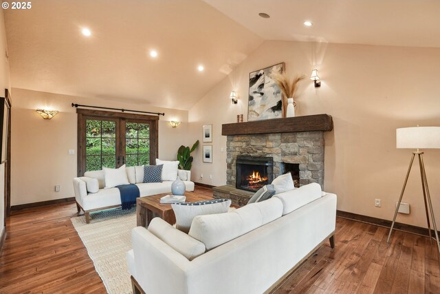living area with a stone fireplace, recessed lighting, wood finished floors, and baseboards