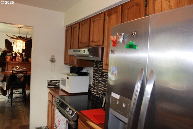 1783 View St, Myrtle Point, OR 97458 - kitchen featuring appliances with stainless steel finishes, under cabinet range hood, brown cabinets, dark countertops, and dark wood-style flooring