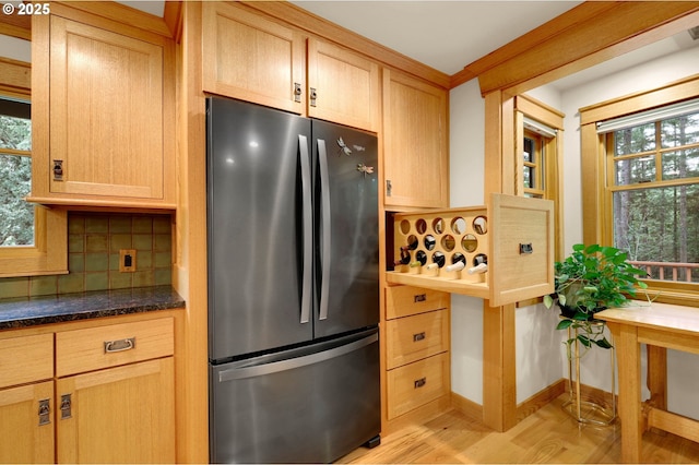 24780 Lavell Rd, Junction City, OR 97448 - kitchen with freestanding refrigerator, tasteful backsplash, light wood-style flooring, dark stone counters, and baseboards