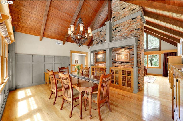 24780 Lavell Rd, Junction City, OR 97448 - dining space with a chandelier, light wood-style floors, a decorative wall, wooden ceiling with exposed beams, and high vaulted ceiling