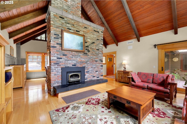 24780 Lavell Rd, Junction City, OR 97448 - living area with wooden ceiling with exposed beams, light wood-style floors, a wood stove, and high vaulted ceiling