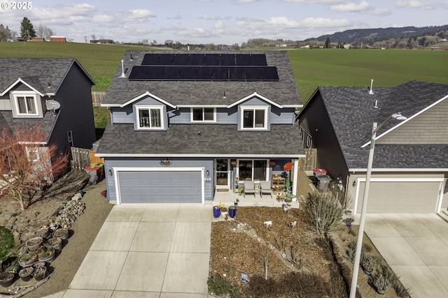 view of front of house with a porch, concrete driveway, a shingled roof, and roof mounted solar panels