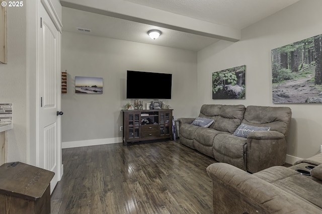 living area featuring visible vents, a textured ceiling, wood finished floors, beamed ceiling, and baseboards