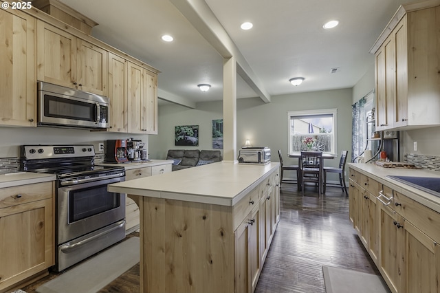 kitchen featuring light brown cabinets, stainless steel appliances, and light countertops