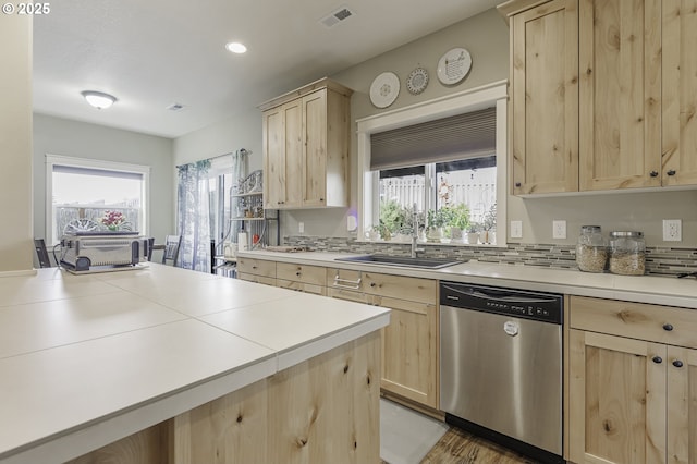 kitchen with a sink, light brown cabinets, visible vents, and stainless steel dishwasher