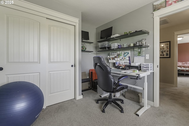 office space with a textured ceiling, carpet, visible vents, and baseboards