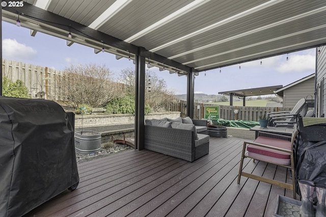 deck featuring grilling area, a fenced backyard, and an outdoor living space