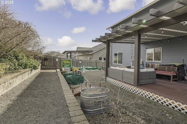 view of patio with fence, a wooden deck, and an outdoor hangout area