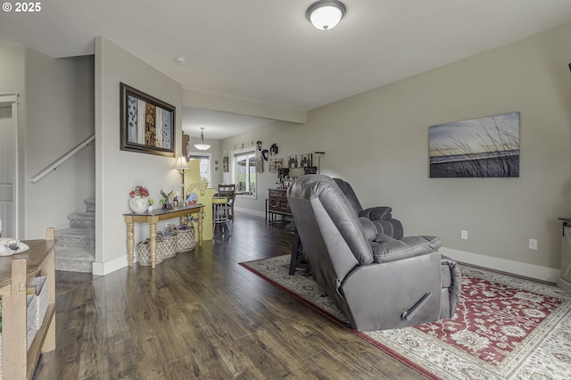 living area with stairs, baseboards, and wood finished floors